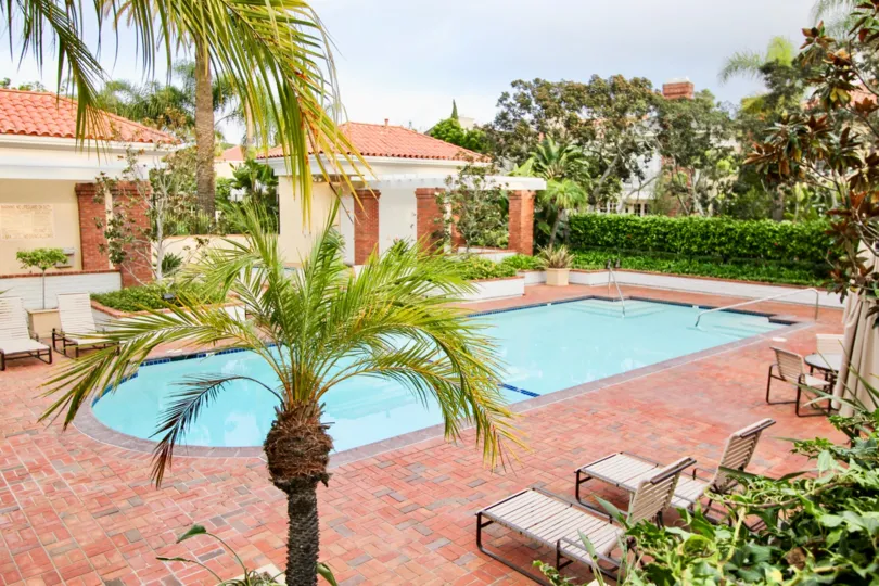 THE HOUSE IN THE BELCOURT TOWNE COLLECTION WITH THE SWIMMING POOL, CHAIRS, PLANTS, TREES