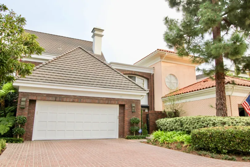 A sunny day in the Belcourt Towne Collection with an entrance of a house and plants.