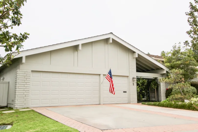 An American flag hangs from the wall of two garages of a white house in the Big Canyon Deane community in Newport Beach, California.