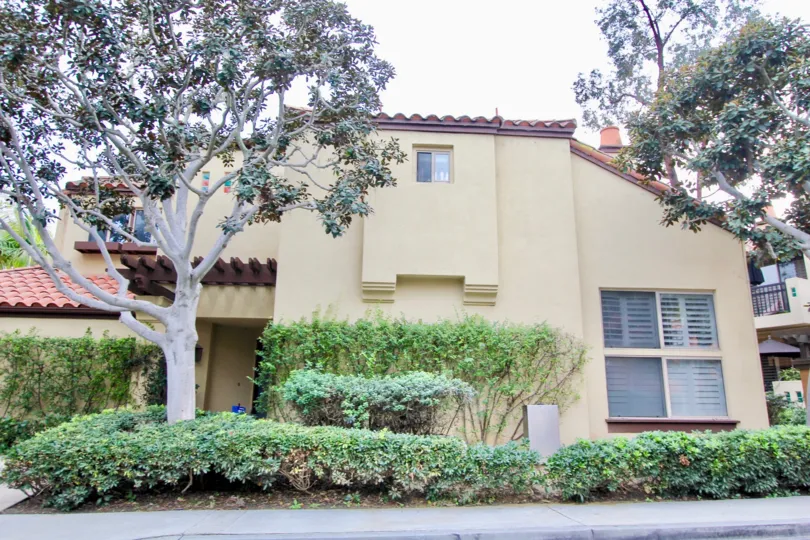 a warm day in the big canyon villas with house that has top of window and tree at front