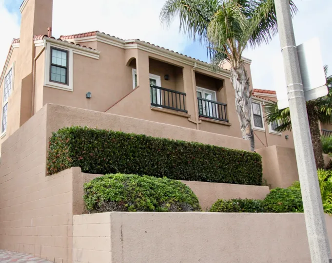 A sunny day in the Brookview Newport with a house and palm tree.