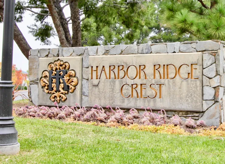 a warm day in the harbor ridge crest with building that has stone walls and garden