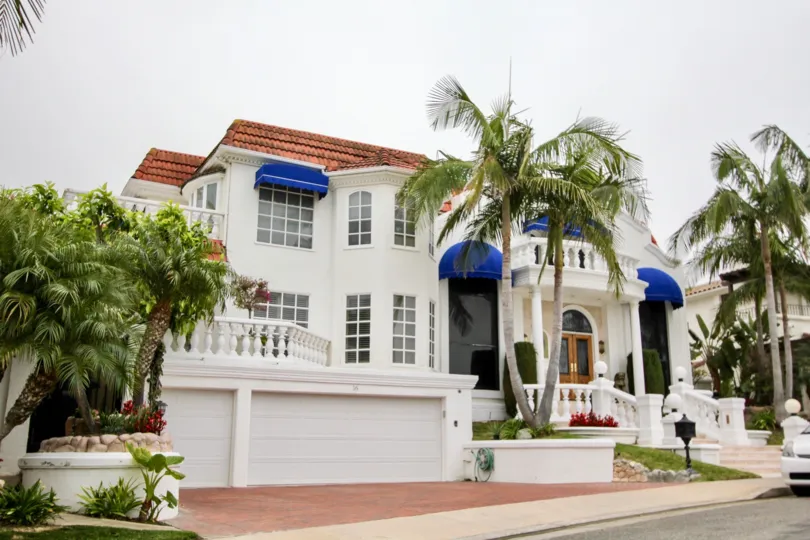 a warm day in theharbor ridge estates with house that has garden in front and windows on top is blue