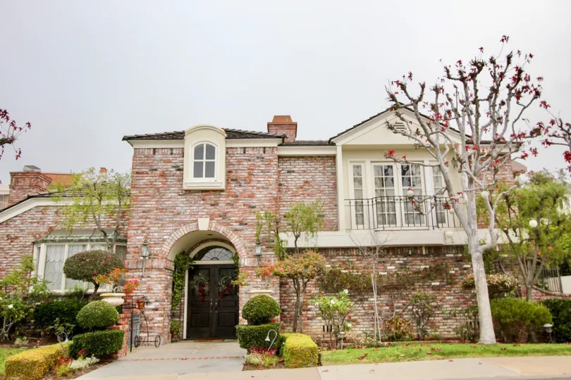 THE ESTATE IN THE HARBOR RIDGE ESTATES WITH THE LAWN, PLANTS, TREES, BALCONI
