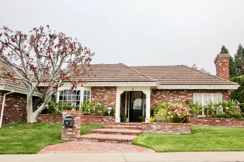 a pleasant day in the harbor ridge estate with a house that is made up of bricks and has tree in front