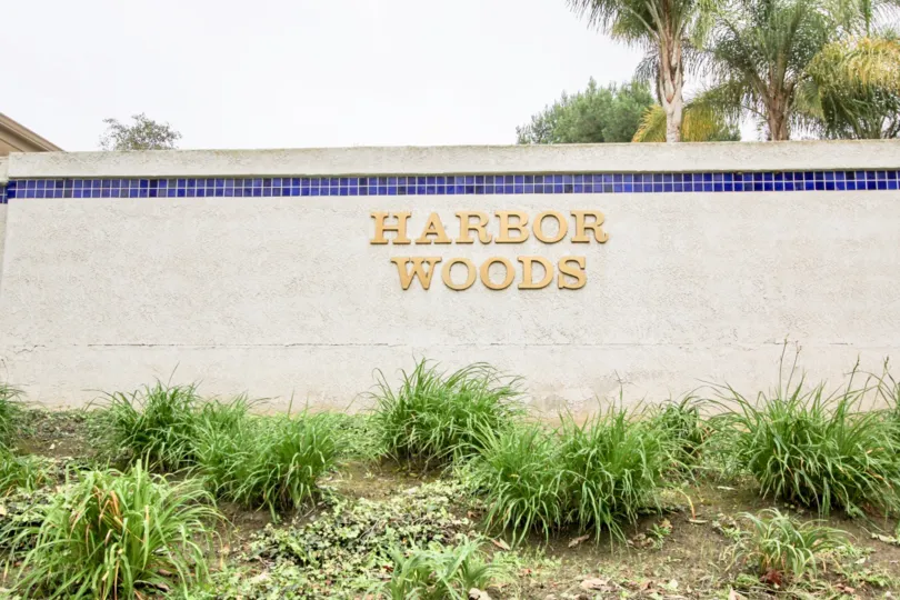 A sunny day in the Harbor Woods with a sign on the wall.