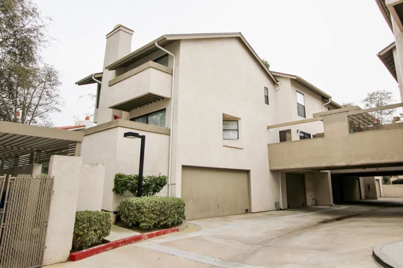 Side view with garage doors and driveway of Harbor Woods community, Newport Beach, CA