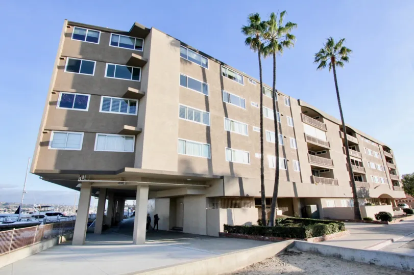 A sunny day in the Newport Bay Towers with a apartment and palm trees.