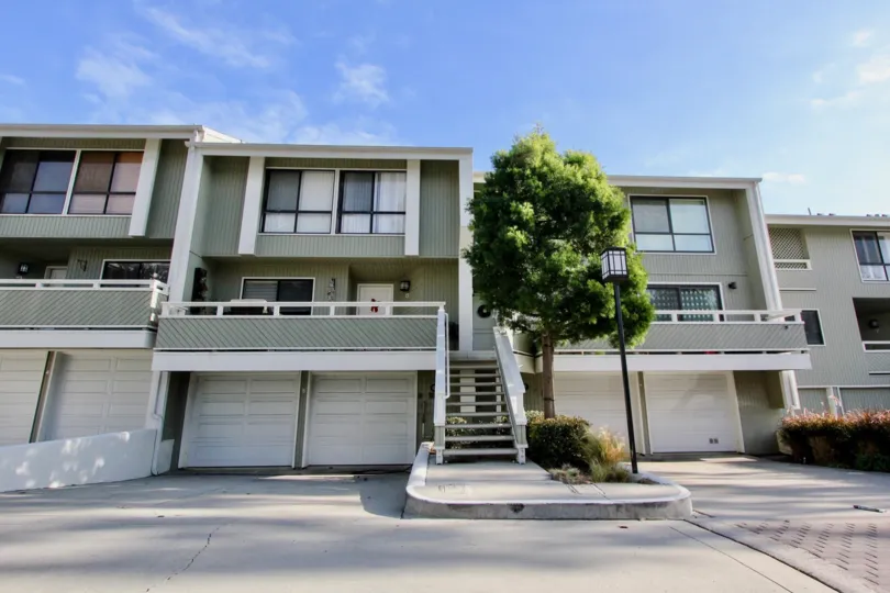 a warm day in the newport crest with house that has doors on white and right of tree