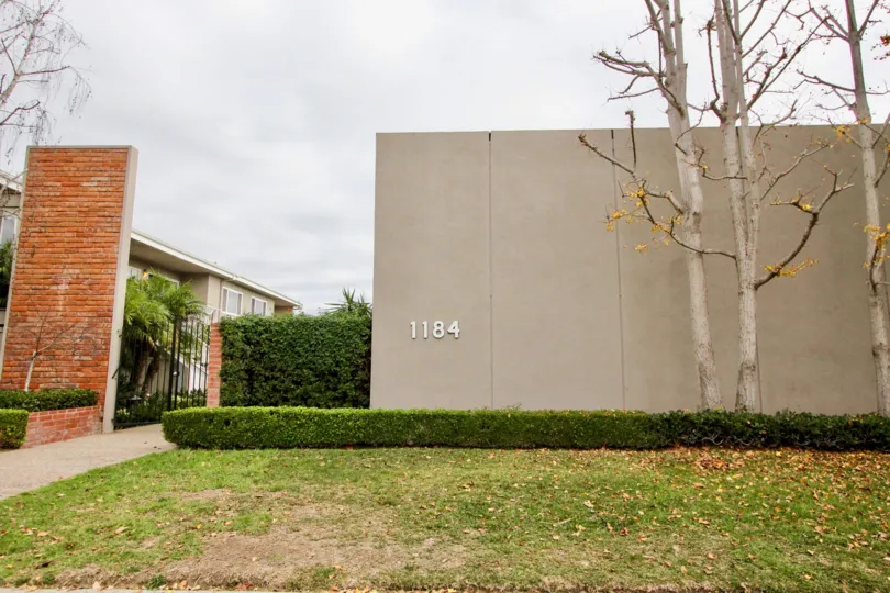 a warm day in the newport garden villas witha building that has large compound wall that is numbered as 1184