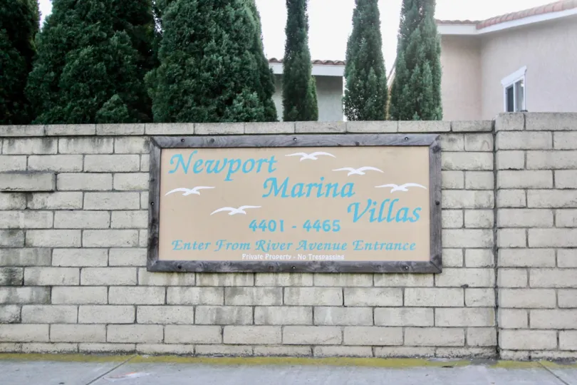 THE HOUSE IN THE NEWPORT MARINA VILLAS WITH THE NAME BOARD, TREES
