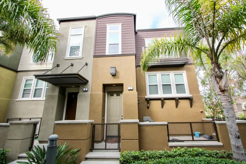 a warm day in the one nautical mile with ahouse that has short steel gate and plant in the front