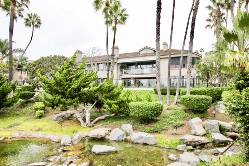 A little pond is placed front of the apartment in Sea Island Lusk with rock and trees