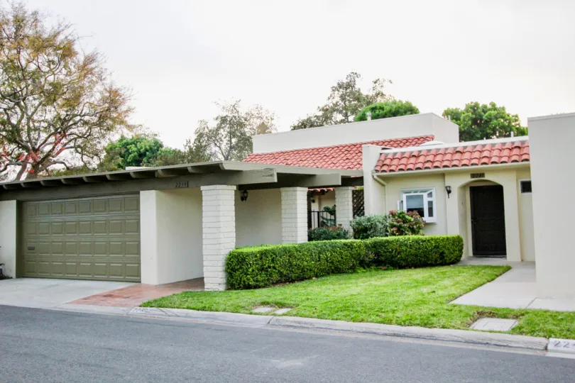 A cloudy day in the The Plaza with a lawn and garage door.