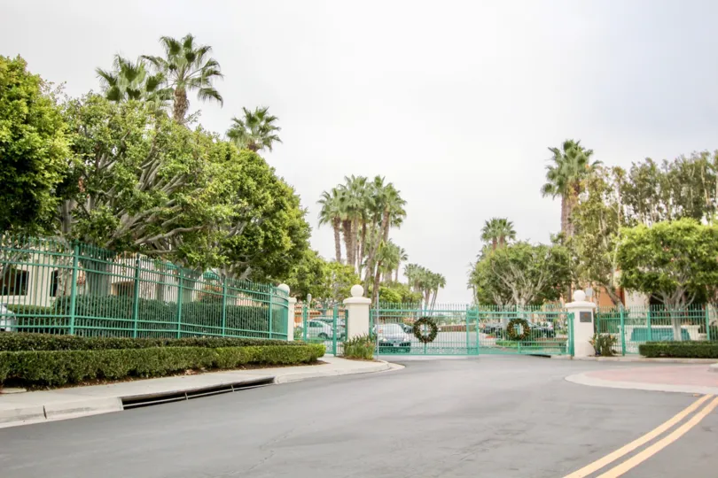 a pleasant day in the villa point with a gated community that has long steel compound and gate and also huge trees