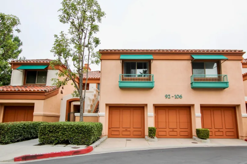 Front side view with garage doors and trees of Villa Point community, Newport Beach, CA