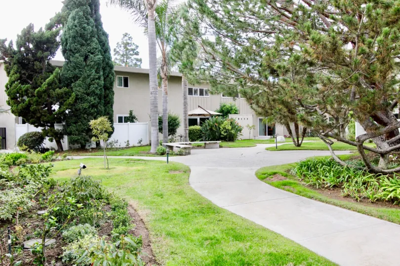 a warm day in the westcliff villas with a building that has big garden and trees around it