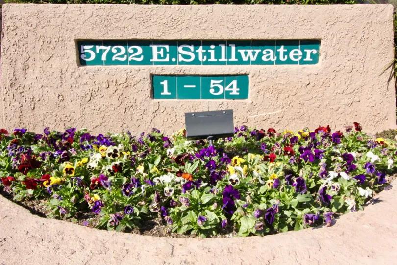 The sign for the Canyon Glen building with a assortment of flowers