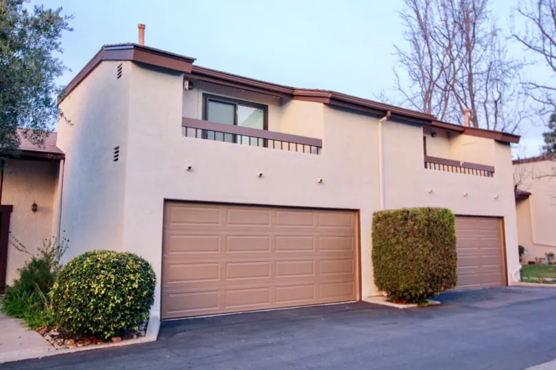 A home in Country Hollow with garage doors and trimmed bushes
