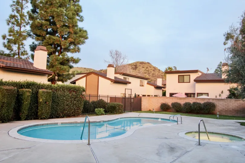 The pool of Country Hollow with bushes and a fence enclosing them