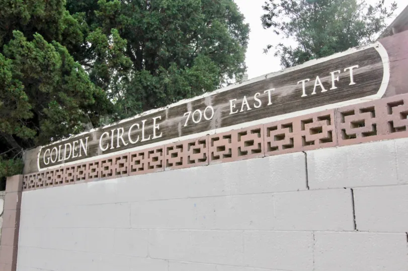 Golden Circle street address on cinder blocks with trees on a cloudy day.