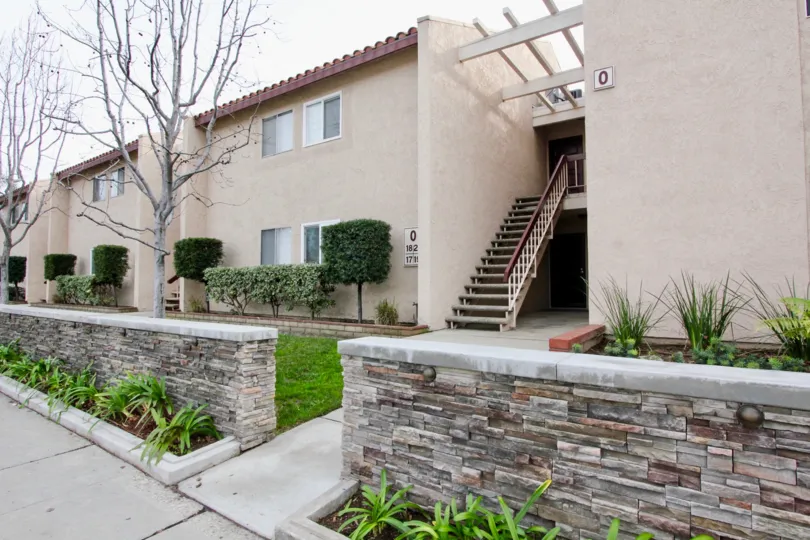 front to the stairs of villa in La Veta Monterey has lawn with cutting bushes and plants