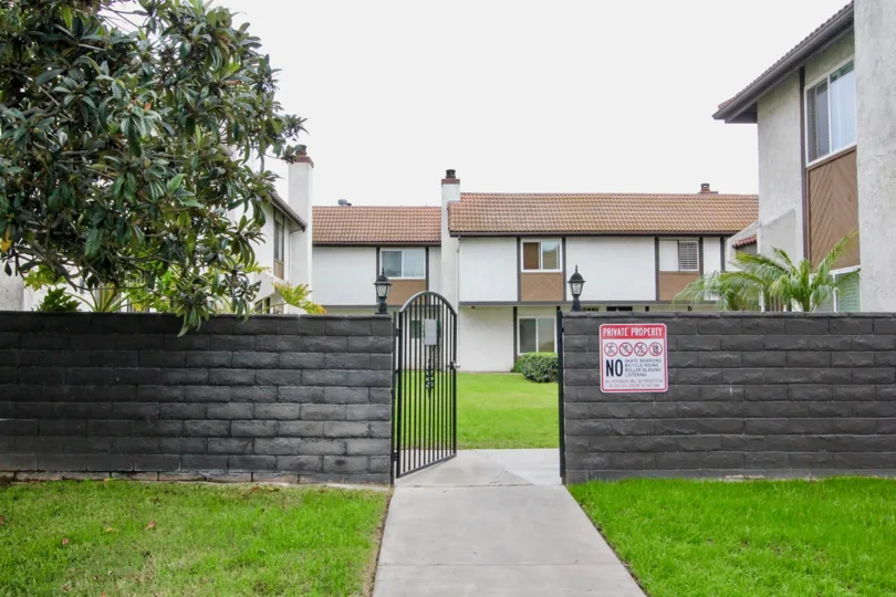 Gated entrance with stone wall at the Lemon Tree in Orange, Ca