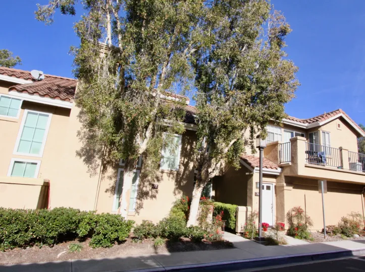 A beautiful day in the Montevista with two trees and building.