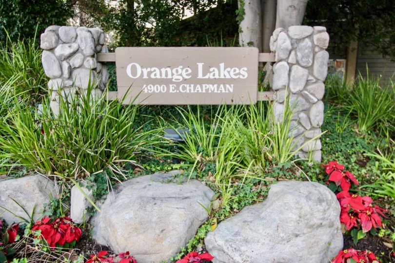 The Oranges Lakes community sign with flowers and plants