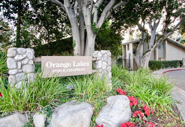 The orange lakes is like a gardening place with lots of green plants and row houses is nearby with big trees and flowers