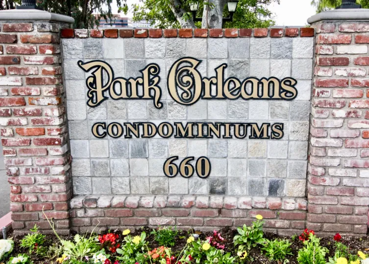 A brick sign with flowers lining the front in Park Orleans Orange, CA.
