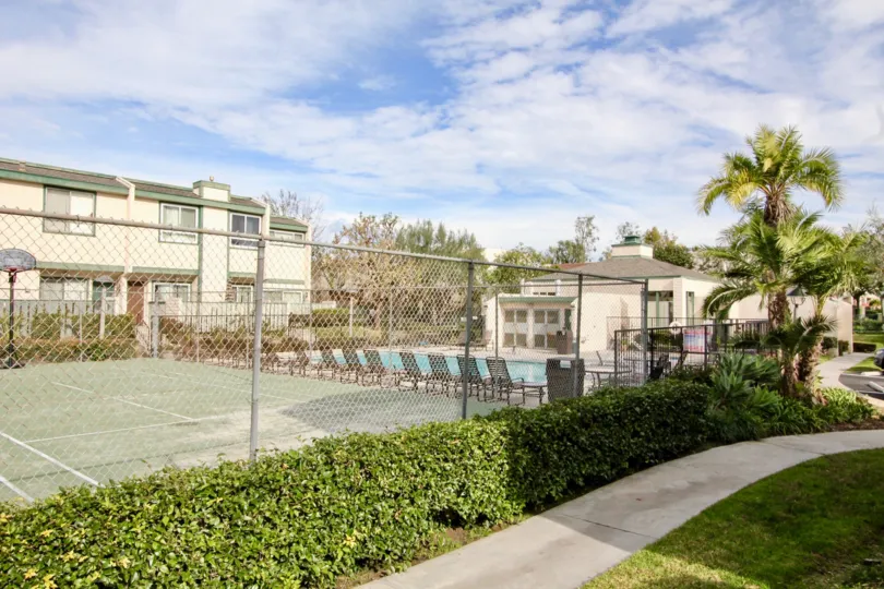 A beautiful day in the Park Terrace Village with a tennis court and palm trees.