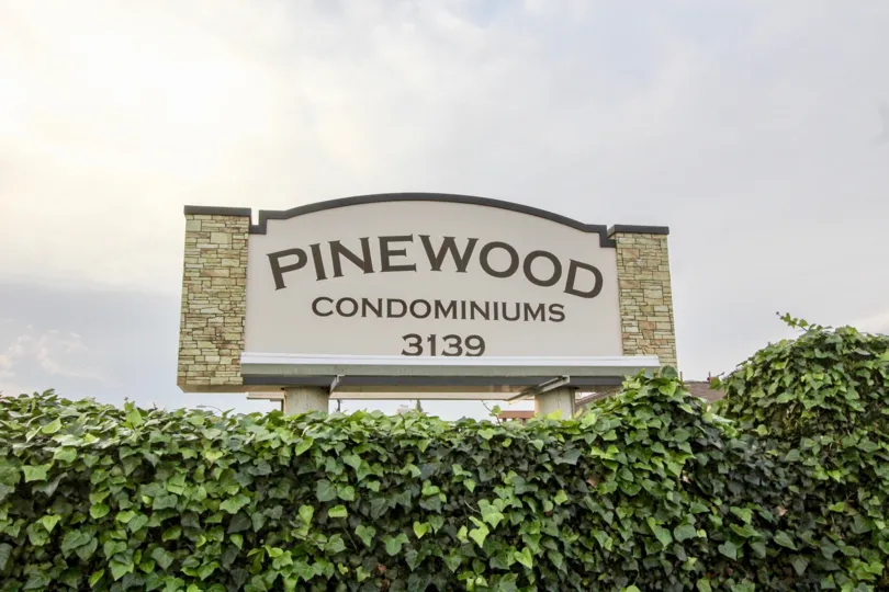 The pinewood condominiums sign in Orange, California, on a cloudy day.
