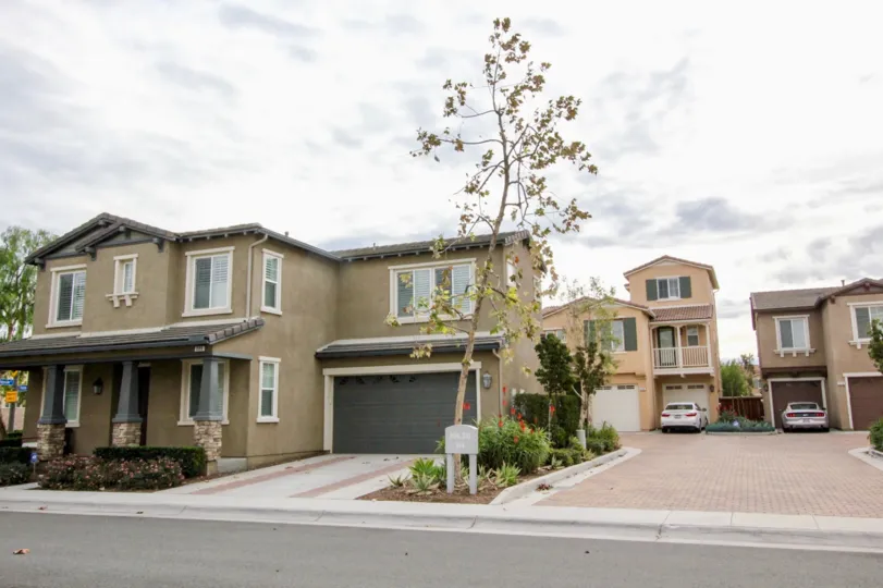 A wide drive way leading to a large house behind another big one in the Riverbend community