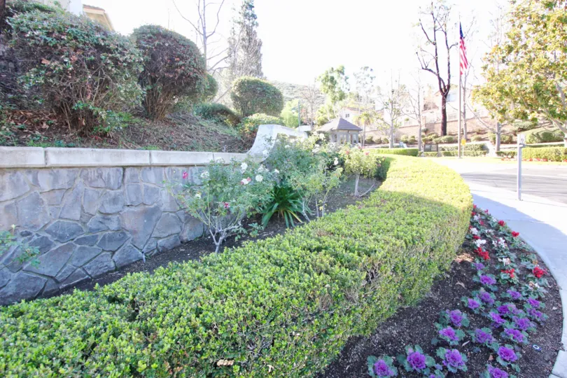 Beautiful garden entrance with bushes, flowers, and three tiers of plants