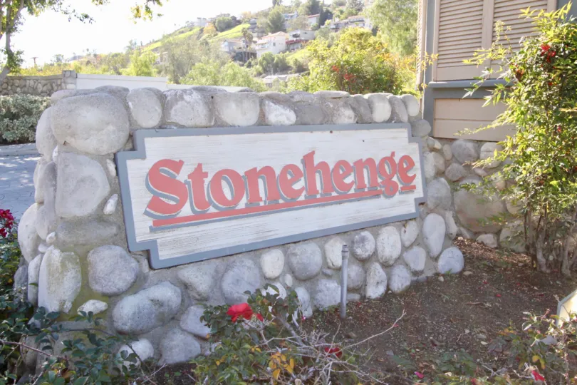 The stone sign for the Stonehenge community with flowers