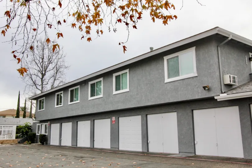 A gray apartment building in Stoneybrook Villas with white garages.