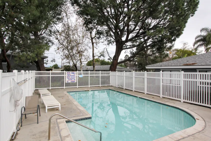 A cloudy day in the Stoneybrook Villas with a swimming pool and trees.