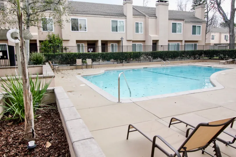 The pool in the Tamarin Orange community with patio furniture and a fence