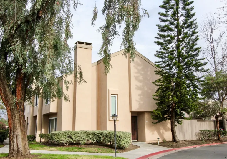 A beige building in Tamarin Orange with trees and bushes