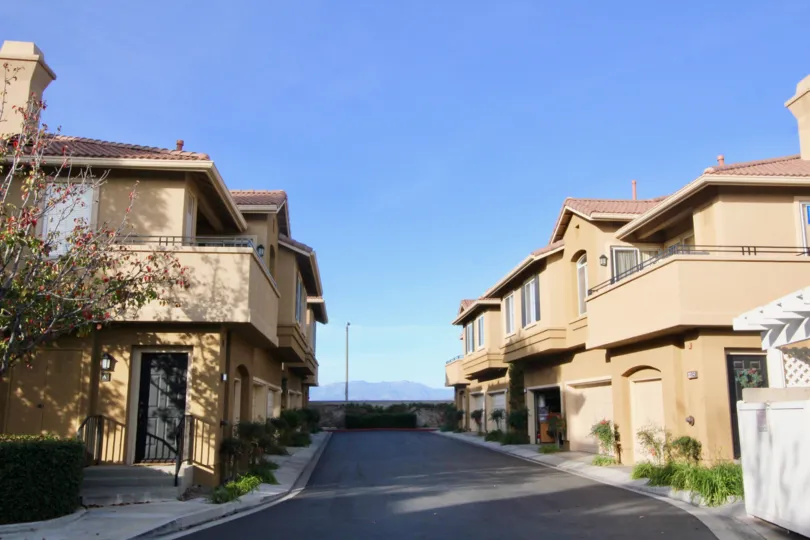Deserted street amid apartments under the blue sky in The Bluffs at Belmont community