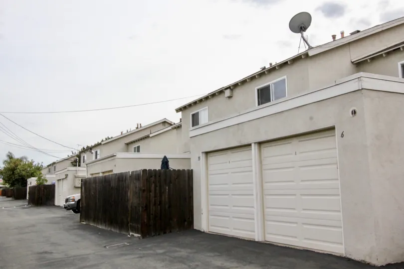 A garage door in a building in the California by a wooden fence