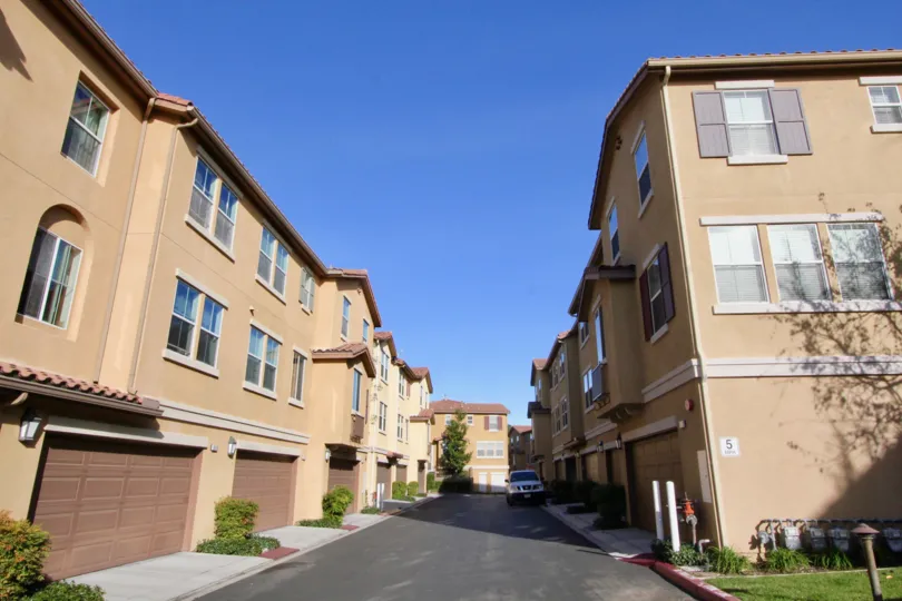 An empty road with row houses on either side inside The Tremont community