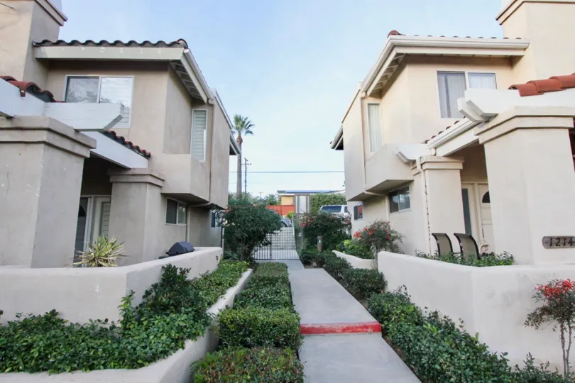 The sidewalk between buildings in the Villa Heights with flowers