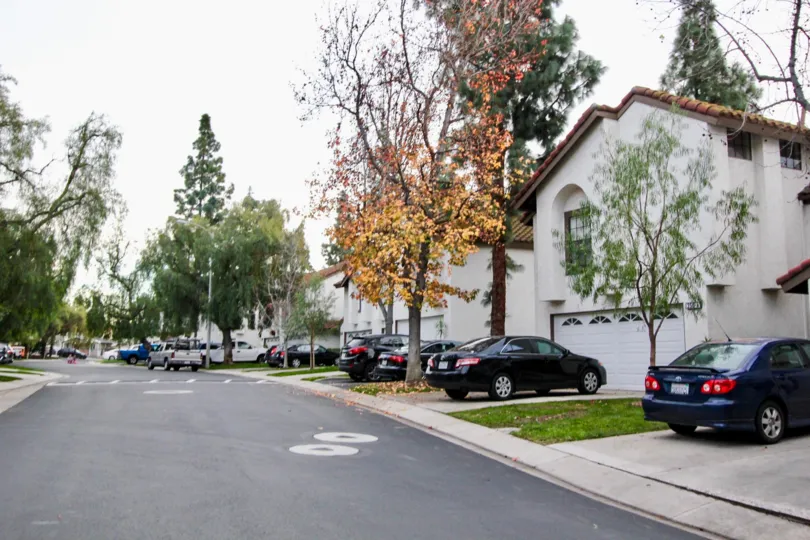 A street in the Villa La Paloma community with cars and trees