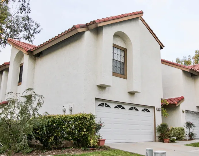A white two story home in Villa la Paloma with a garage