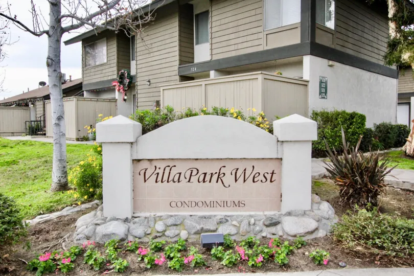 The sign outside a Villa Park West with garden and trees