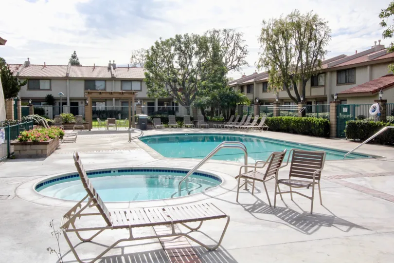 The pool of Vista Monterey with deck chairs and a gate