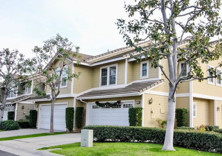 Two story homes in Vista Santiago with garages and trees.