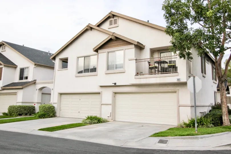 A white two story house in Westbury with two garages